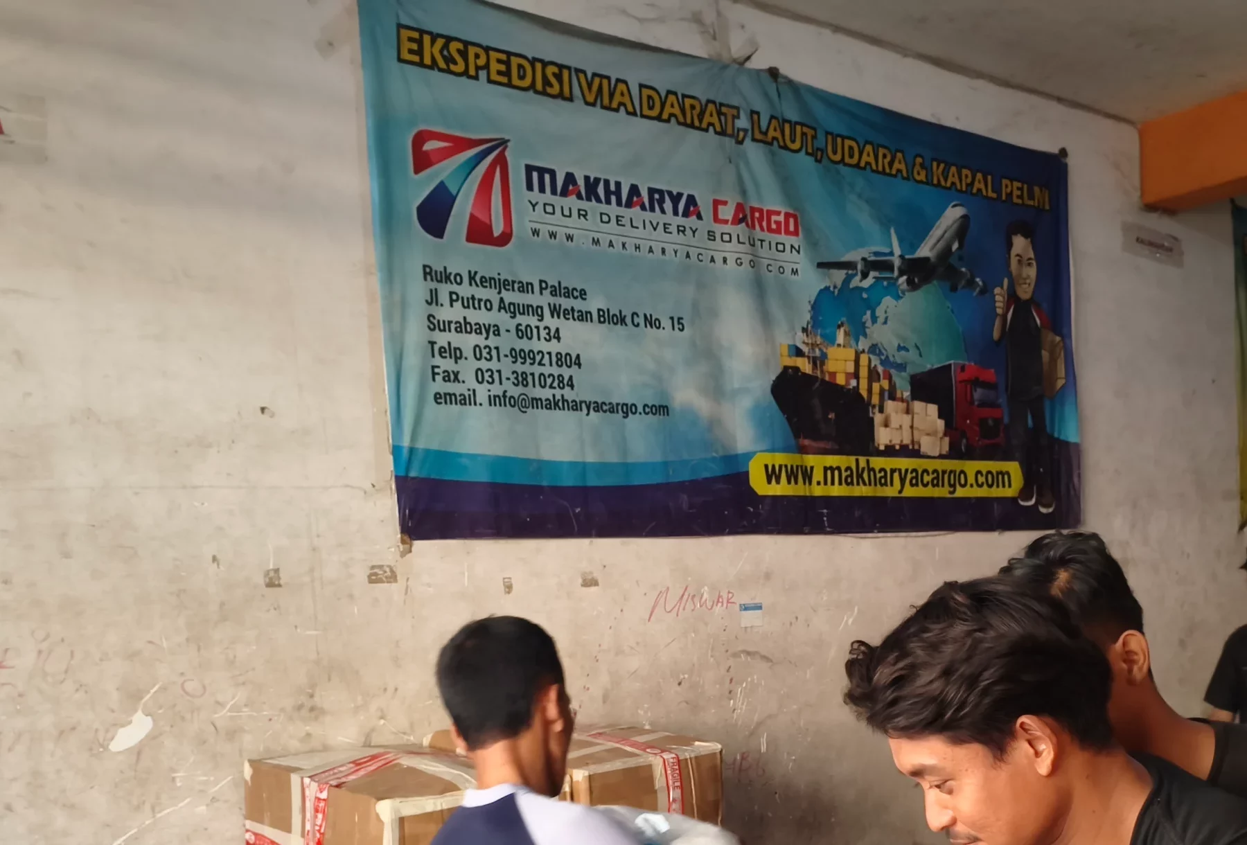 Petugas jasa jemput barang Surabaya Tanah Grogot sedang mengambil barang di lokasi pengirim.
